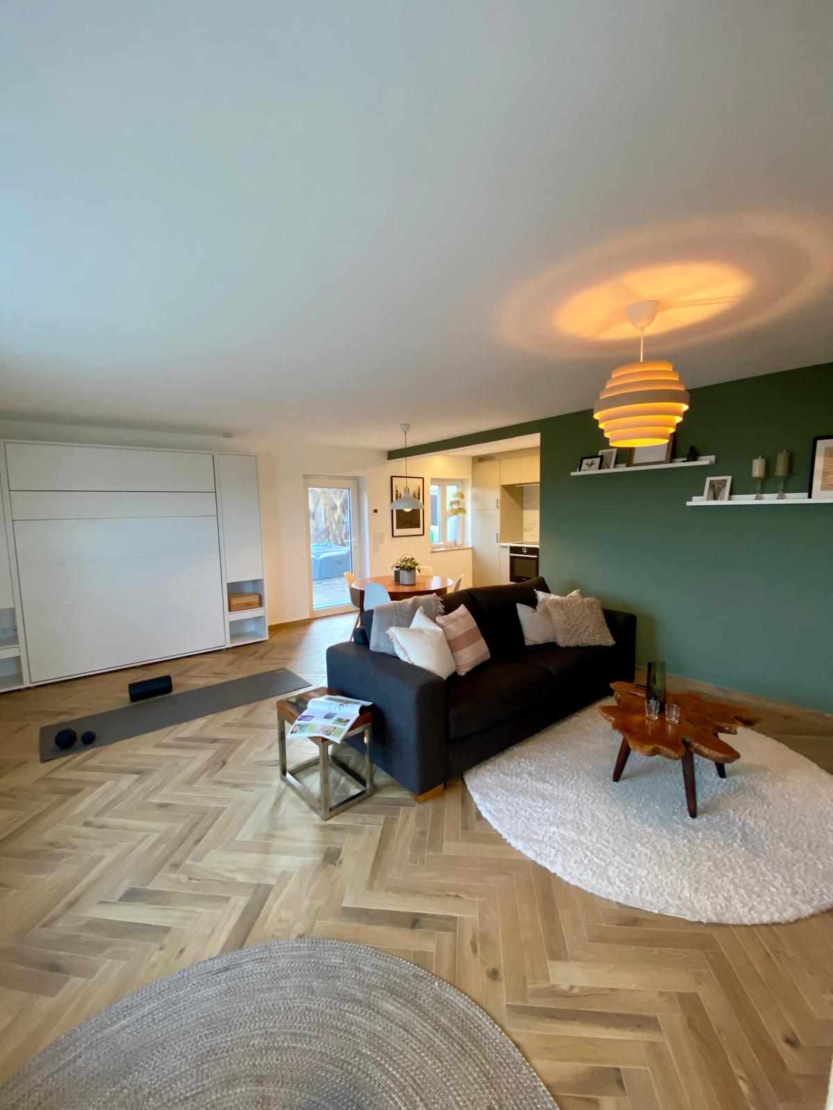 Wohnzimmer offener Grundriss grüne Wand